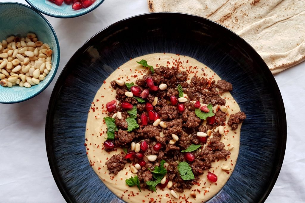 Delectable Arabian dish that combines creamy hummus with savory spiced lamb. This recipe features a velvety hummus base topped with flavorful ground lamb sautรฉed with aromatic spices.