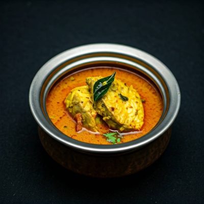 Kerala-style fish curry with ground coconut (Thenga Arachathu) served in a traditional bowl